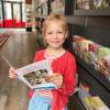 Die 6-J&auml;hrige Emilia schaut sich in der Tourist Information den Ferienkalender der Stadt Halberstadt an.